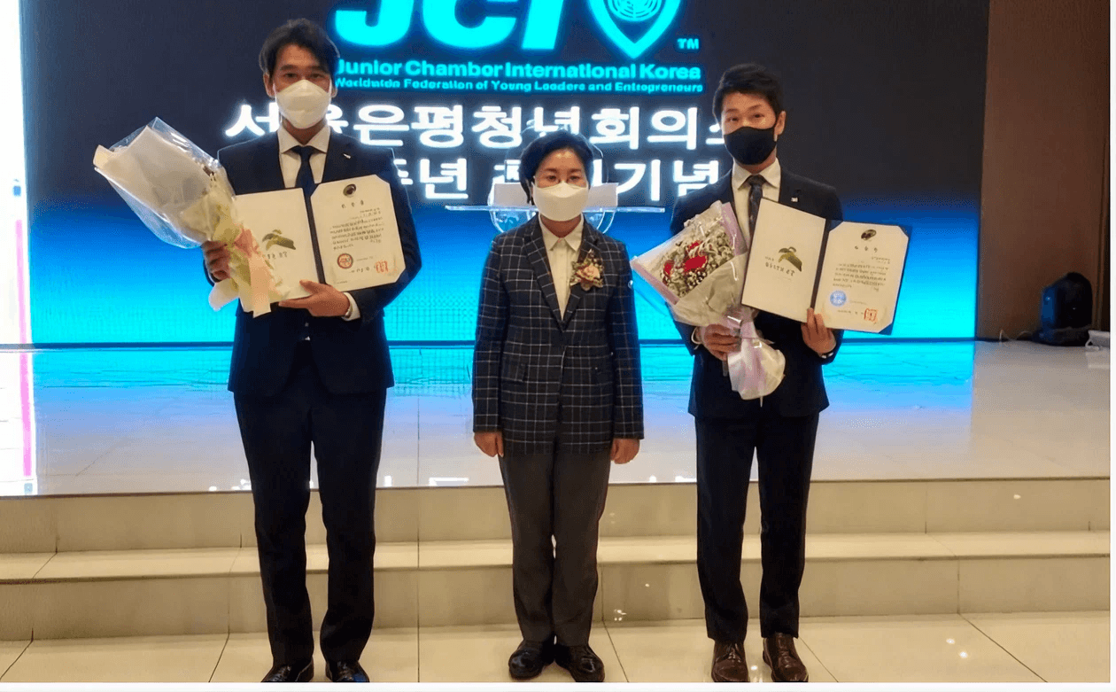 JCI 시상식에서 상패와 꽃다발을 전달받는 모습